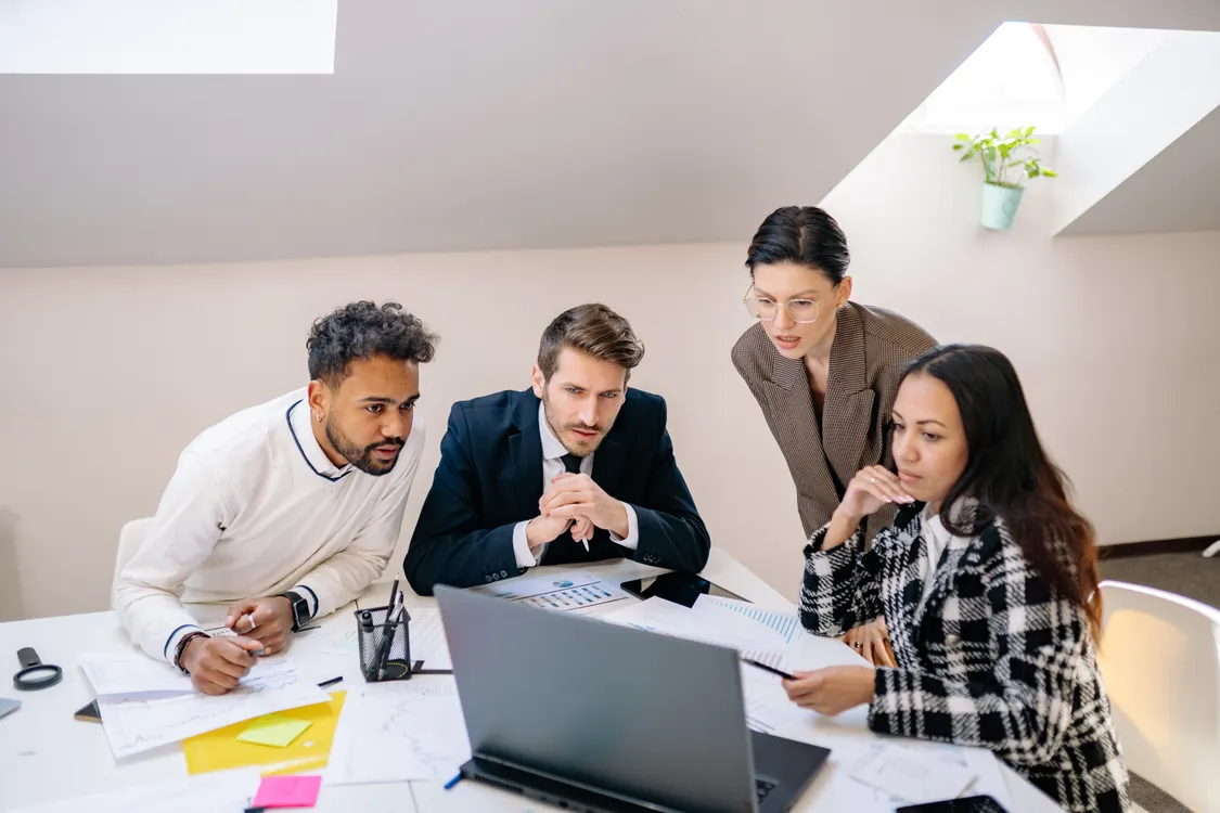 Profesionales del equipo revisando informes y datos en una oficina moderna